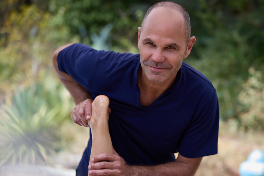 Patrick Gaveau pratiquant une technique de massage thaï traditionnel sur une cliente, combinant étirements et pressions pour libérer les tensions et rétablir l’énergie.