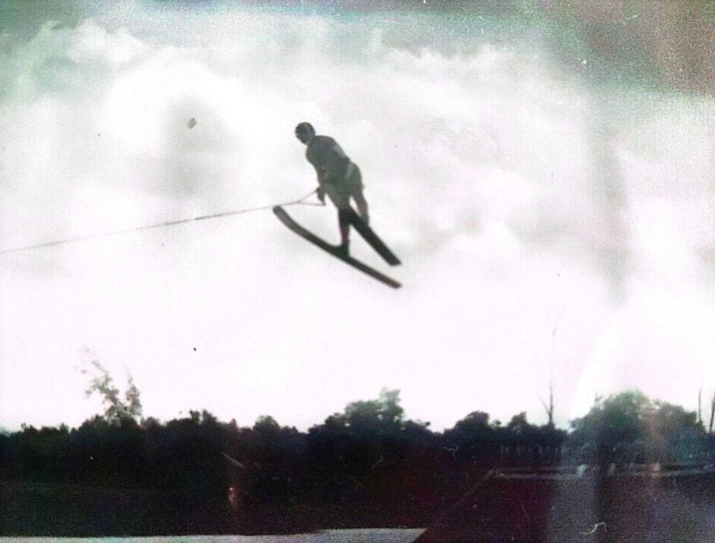 Patrick Gaveau réalisant un saut en ski nautique, illustrant une étape sportive et dynamique de sa vie.