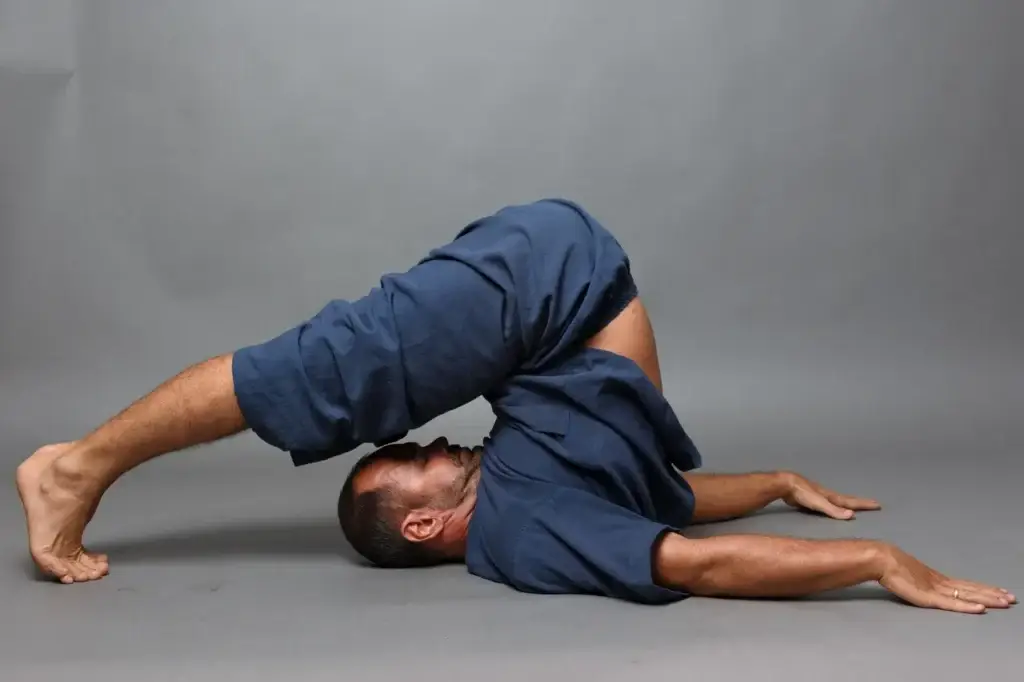 👉 Patrick Gaveau pratiquant un asana inversé, illustrant le yoga de conscience, où la respiration, la présence et l’énergie sont aussi essentiels que les postures.