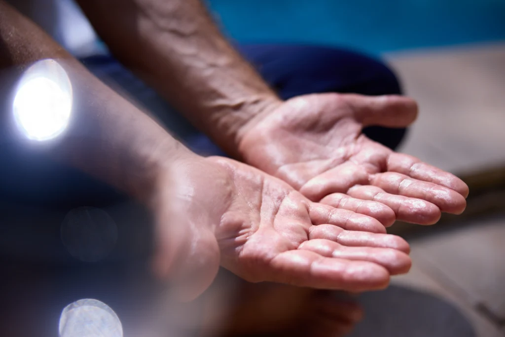 Mains d’un praticien de massage, fortes, sensibles et attentives, prêtes à offrir un soin personnalisé
