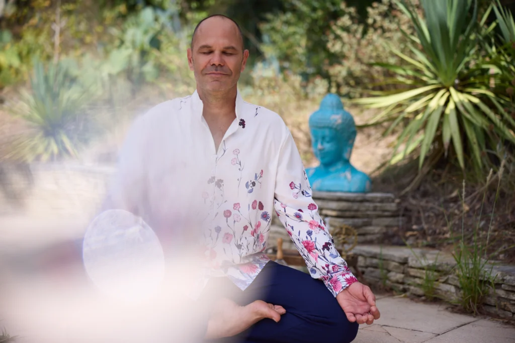 Patrick Gaveau méditant en tailleur, les yeux fermés, incarnant le calme intérieur, la pleine présence et l’essence du yoga au-delà des postures.