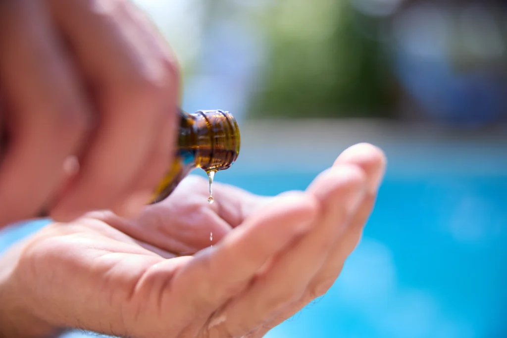 Patrick Gaveau using Ayurvedic oil in his hand, ready to apply it during a therapeutic massage.